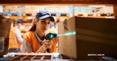 Female warehouse worker uses bar code reader while scanning packages at storage compartment